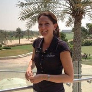 Bio Image of Kelly Bridges standing on balcony at Al Badia Golf Club in Dubai