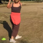 Image of a woman playing golf on a fairway during a Love.golf group class