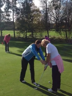 mage of Kelly Bridges, Golf Coach, demonstrating how to address a ball when putting