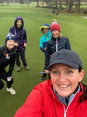 Image of Kelly Bridges, women's golf lessons coach in Dorset, with some of her die-hard Love.golf beginner ladies. Guess they weren't expecting to brave the elements during #StormBarra in Dec 2021 but their smiling faces reflects what Love.golf is all about, having fun.